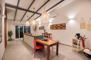 Villas Mar y Coral في بويرتو فيجو: مطبخ مع طاولة خشبية وكراسي حمراء
