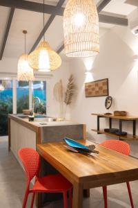 a kitchen with a wooden table and red chairs at Villas Mar y Coral in Puerto Viejo