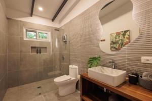 ein Badezimmer mit Toilette, Waschbecken und Dusche in der Unterkunft Villas Mar De Coral in Puerto Viejo