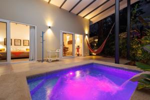 a swimming pool with a hammock in a house at Villas Mar y Coral in Puerto Viejo