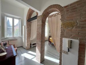 a living room with a brick wall and an archway at CriLo Pisa in Pisa