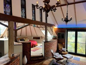 um quarto com uma cama numa parede de tijolos em Unique luxury self-contained oast apartment em Kent