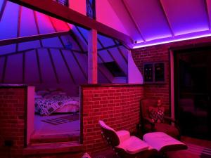 a room with a room with a bed and purple lights at Unique luxury self-contained oast apartment in Kent