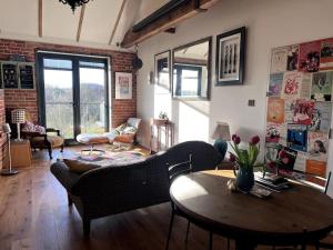 a living room with a couch and a table at Unique luxury self-contained oast apartment in Kent