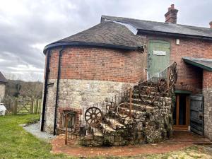 an old brick building with a fence and a door at Unique luxury self-contained oast apartment in Kent