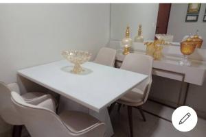 a white dining room table with chairs and a white table at ESPAÇO ACONCHEGANTE NO SUDOESTE in Brasilia