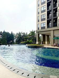 uma grande piscina em frente a um edifício em Apt Transpark Cibubur 2 BR With Wi-Fi & Pool em Kalimanggis