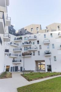 a large white building with balconies on the side of it at Escapade parisienne à 25 minutes de la Tour Eiffel in Villeneuve-la-Garenne