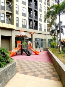 um parque infantil em frente a um edifício alto em Apt Transpark Cibubur 2 BR With Wi-Fi & Pool em Kalimanggis