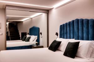 a hotel room with two beds and a mirror at Piazza Farnese Luxury Suites in Rome