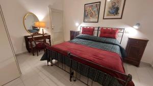 a bedroom with a bed with red pillows and a mirror at CriLo Pisa in Pisa