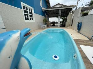 a swimming pool with a dolphin in a house at Casa para Família com Lazer Total - Próximo Aeroporto in Lauro de Freitas