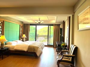 a bedroom with a large bed and a balcony at Quinstel Hostel in Bangkok