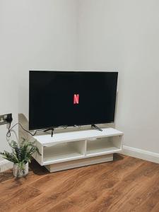 a flat screen tv sitting on a white entertainment center at CentralGem Retreat 02 in Redditch