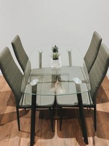 a glass table with four chairs and a plant on it at CentralGem Retreat 02 in Redditch