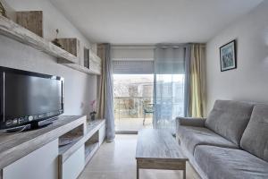 een woonkamer met een bank en een flatscreen-tv bij apartament de luxe con piscina in Salou