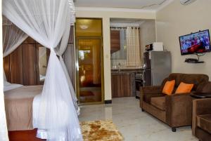 - une chambre avec un lit et un salon dans l'établissement Jengel Studio Apartments Entebbe 1, à Entebbe