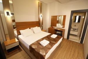 a bedroom with a large bed and a bathroom at ALMIRCAN HOTEL in Trabzon