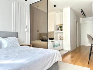 een witte slaapkamer met een bed en een keuken bij Bulevard57 in Belgrado