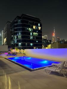 una piscina en la azotea de un edificio por la noche en Diamond Jumeirah Garden City 1, en Dubái