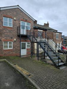 a brick house with a staircase in front of it at 38 Church Street Luxury Flat in Warrington