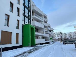 un edificio de apartamentos con una puerta verde en la nieve en Prestige 1, en Opole