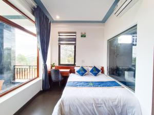a bedroom with a bed and a window at Khe Sanh Luxury Hotel in Hương Hóa