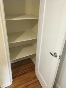 a closet with a white door and some shelves at Suite 55 in Elmwood Park