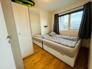 Cette petite chambre comprend un lit et une fenêtre. dans l'établissement 2 bedroom apartment in great location, à Kristiansand