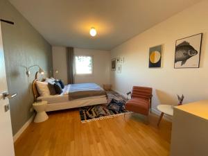 a bedroom with a bed and a chair in it at Villa Rebgärtle mit Seeblick in Bregenz