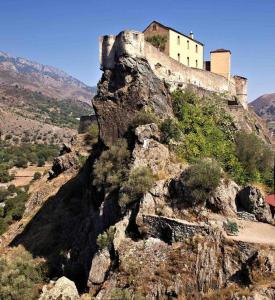 a castle on top of a rocky mountain at Magnifique Studio dans Résidence neuve in Corte