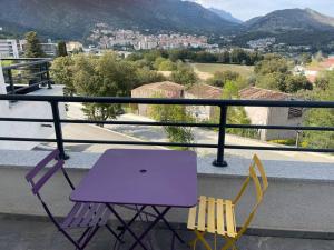 einen lila Tisch und zwei Stühle auf dem Balkon in der Unterkunft Magnifique Studio dans Résidence neuve in Corte
