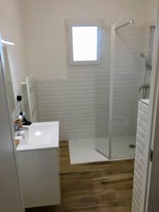 a white bathroom with a shower and a sink at Magnifique Studio dans Résidence neuve in Corte +13 photos