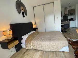 a bedroom with a bed and a table with lamps at Magnifique Studio dans Résidence neuve in Corte