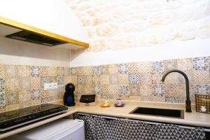 eine Küche mit einer Spüle und einer Arbeitsplatte in der Unterkunft La Suite del Conte - STORIA, CONFORT ed ELEGANZA in Ceglie Messapica