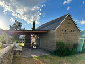 een oude stenen schuur met een metalen dak bij Eittel Guest Farm Cottage in Winburg