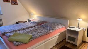 ein Schlafzimmer mit einem Bett mit zwei Nachttischen und zwei Lampen in der Unterkunft Ferienhaus Wilhelmshaven Voslapp 78 in Wilhelmshaven