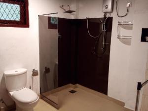 uma casa de banho com um chuveiro e um WC. em Diyagal Villa 