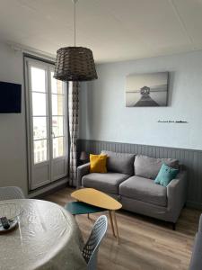 salon z kanapą i stołem w obiekcie Superbe appartement front de mer w mieście Luc-sur-Mer