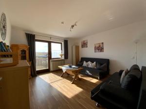 a living room with a couch and a table at Sunny apartment in Pähl in Pähl