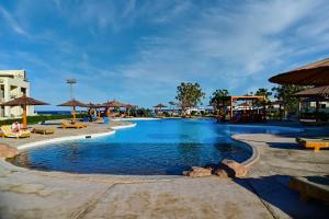 una piscina in un resort con sedie e ombrelloni di New Eagles Aqua Park Resort a Hurghada