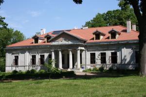 an old house with a red roof at Dwór Bieganów in Bieganów