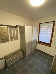 ein Bad mit einem Fenster und Fliesenboden in der Unterkunft Krušnohorský apartmán in Kraslice