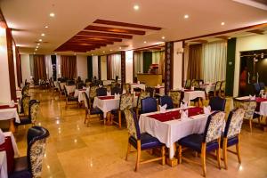 una sala da pranzo con tavoli, sedie e una tavola di New Eagles Aqua Park Resort a Hurghada
