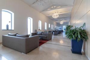 a lobby with couches and a plant in the middle at Art Apartment In Mamila - King David Residence in Jerusalem +53 photos