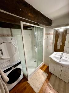 y baño con ducha, lavabo y lavadora. en L'abri-côtier, en Saint-Suliac