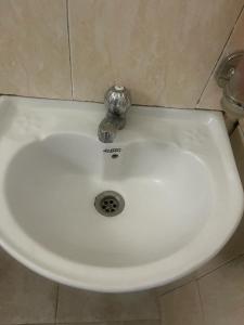 a white sink with a silver faucet in a bathroom at Retreat Homes in Dar es Salaam