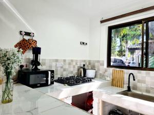 a kitchen with a stove and a sink and a window at Retreat Homes in Dar es Salaam