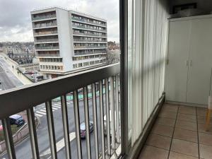 Elle comprend un balcon offrant une vue sur une rue de la ville. dans l'établissement Appartement 80 m2 Île de France Juvisy, à Juvisy-sur-Orge