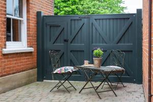a table and chairs in front of a black gate at Stylish and homely 1 bed Edwardian Coach House in Colchester